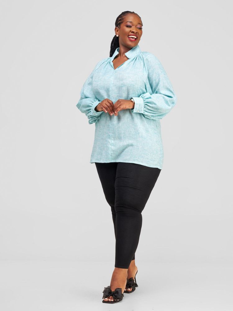 Hip-length blouse featuring long sleeves with stylish cuff details and a single button on each cuff.