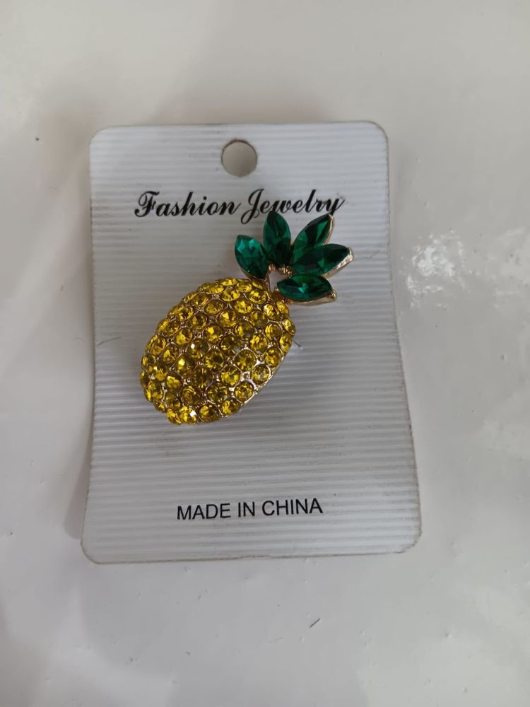 tunning pineapple shaped brooch with gems in bright yellow and dark green red.